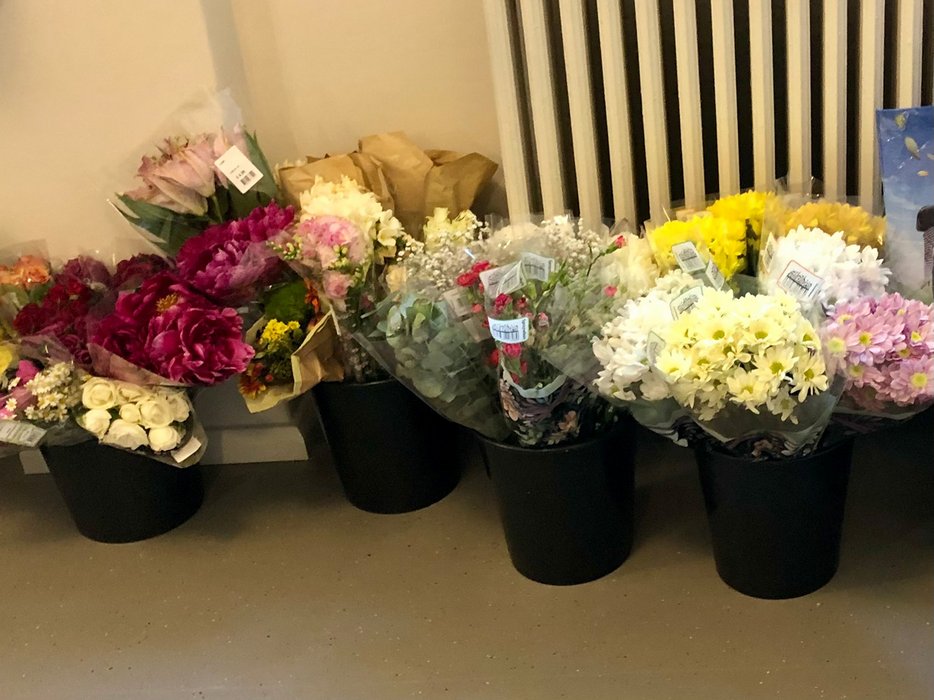 Mehrere Eimer gefüllt mit Blumensträußen