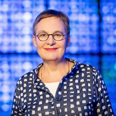 Portrait von Ulrike Trautwein vor blauem Hintergrund.