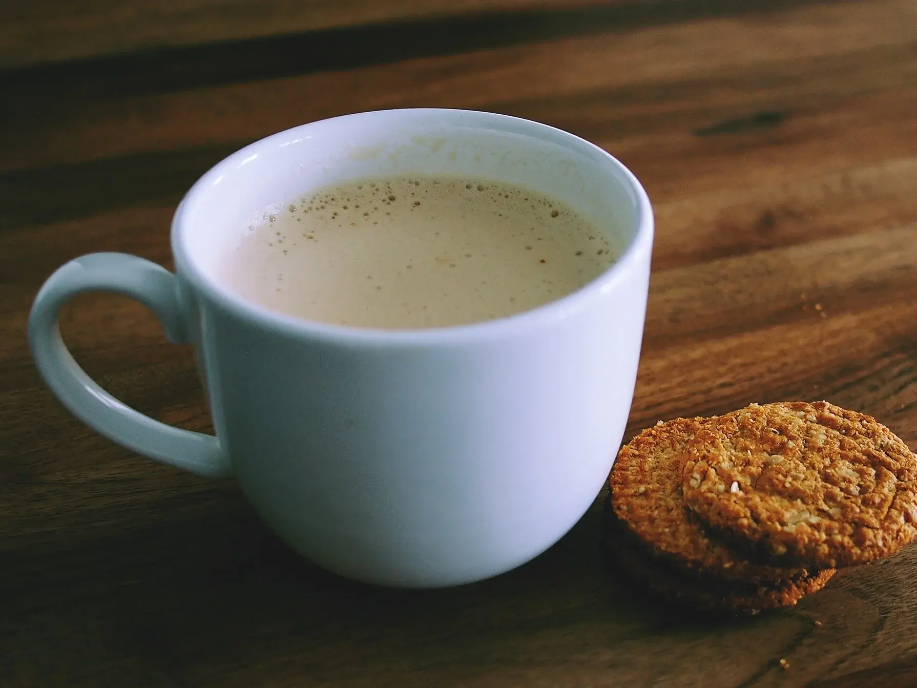 Tasse Kaffe und Kekse auf einem Holztisch