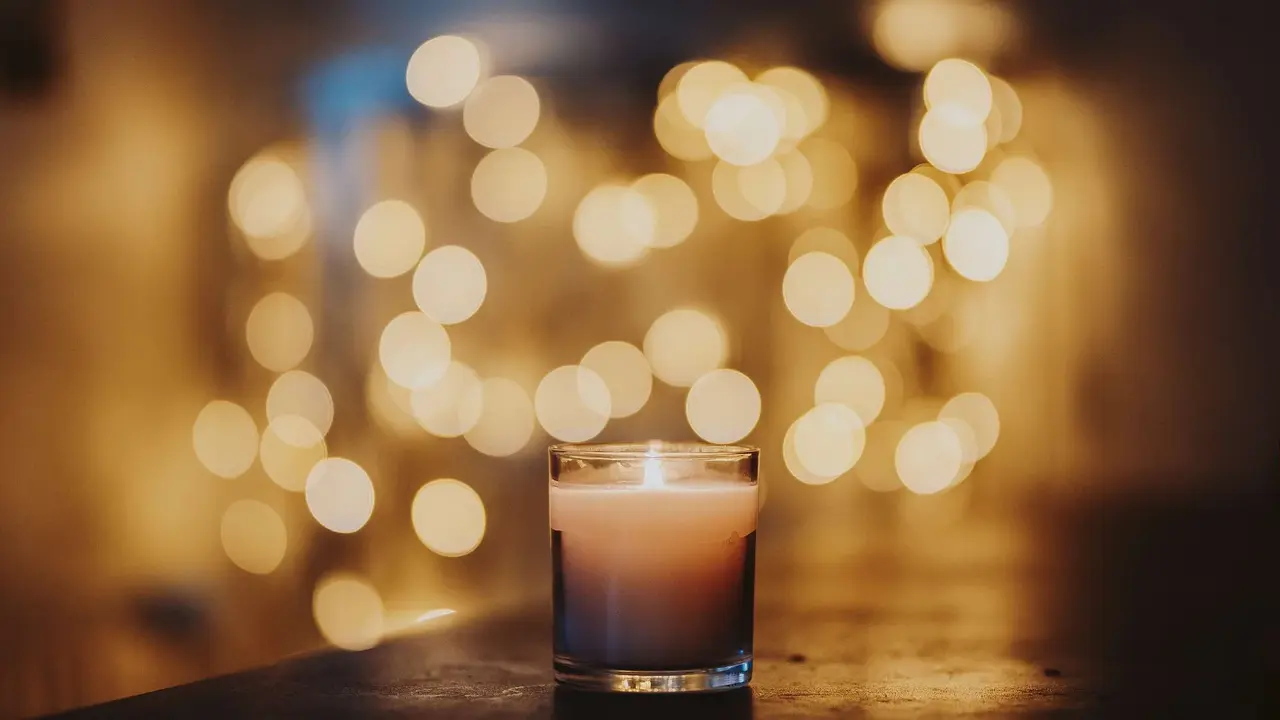 Kerze im Glas mit Lichtpunkten