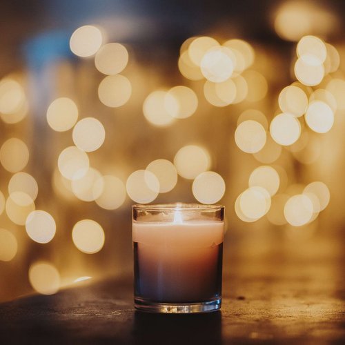 Kerze im Glas mit Lichtpunkten