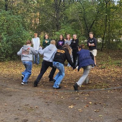 Eine Gruppe von Jugendlichen rennt durch ein Seil