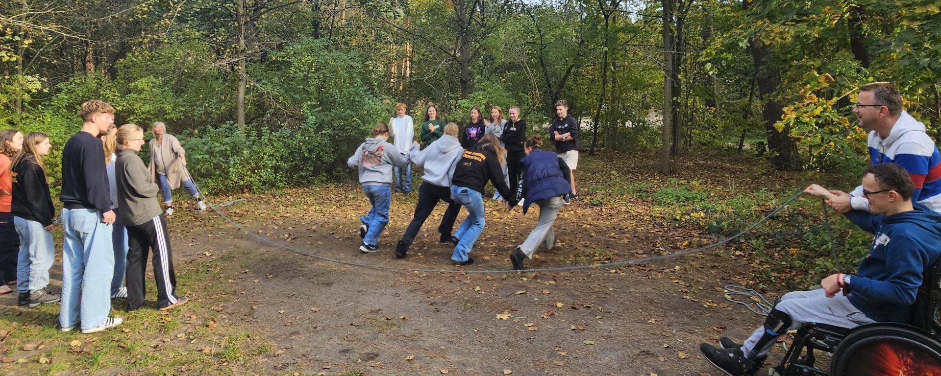 Eine Gruppe von Jugendlichen rennt durch ein Seil