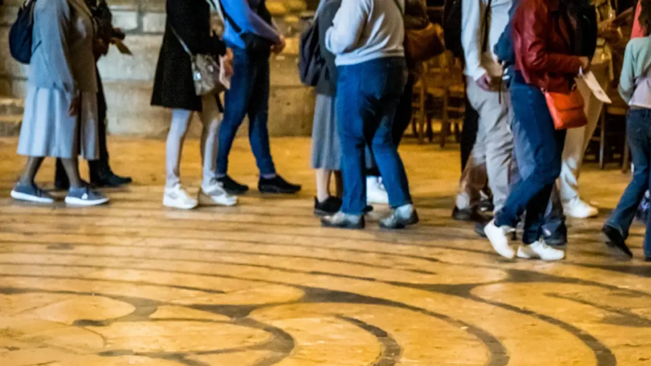 Labyrinth der Kathedrale von Chartres - am Rand sind die Beine einiger Menschen zu sehen, die das Labyrinth ablaufen.