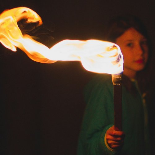 Mädchen in der Dunkelheit, hält brennende Fackel in der Hand