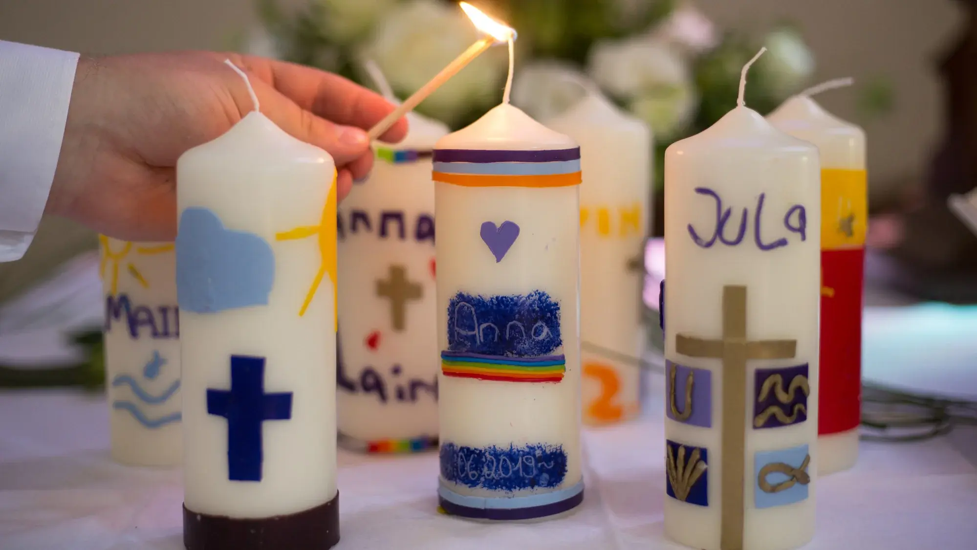 Taufkerzen auf dem Altar werden entzündet