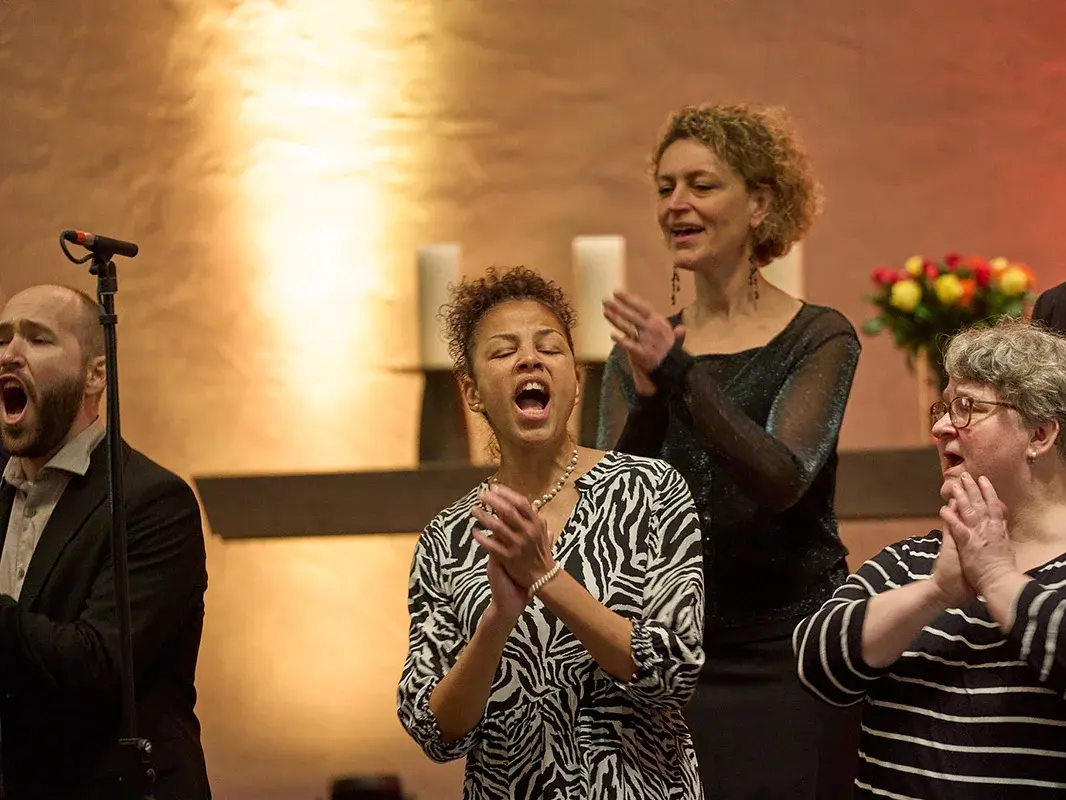 Vier Frauen und ein Mann aus einem Gospelchor, eine Frau singt besonders enthusiastisch